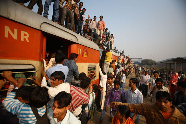 Commuters struggle to enter a train at Noli Railway Station in Uttar Pradesh